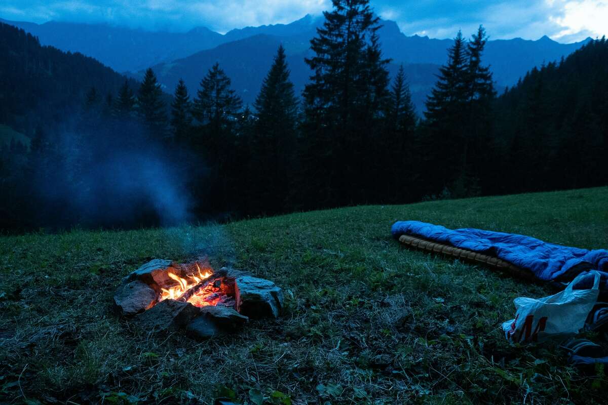 Randonneur se reposant près dun feu de camp ou au coucher du soleil
